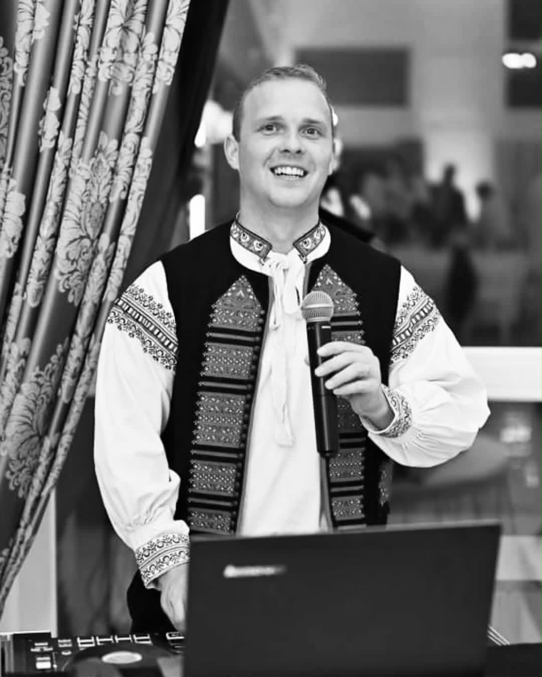 Lukáš Kutiš v slovenskom kroji s mikrofónom za DJ pultom