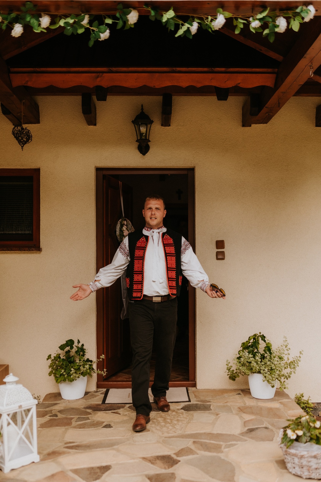 Lukáš Kutiš ako starejší v kroji víta hostí pred domom nevesty